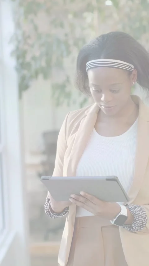 Vertical video: Woman tapping tablet in office lobby, creating animated charts Stock Footage 333862413