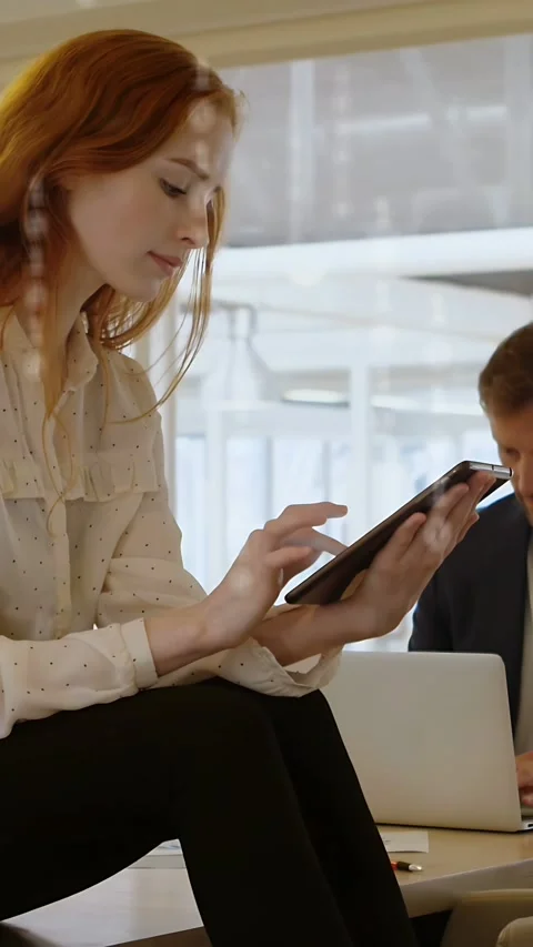 Vertical video: Woman tapping tablet causing 01  and  teal UI peaking, fading Stock Footage 334704856