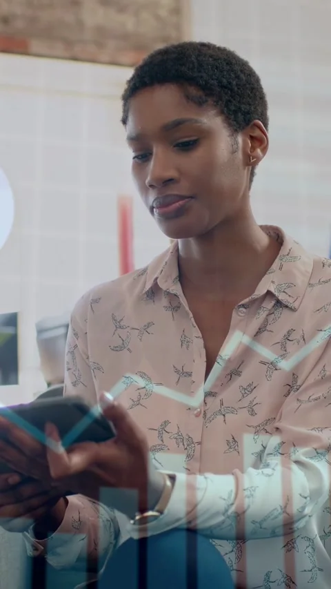 Vertical video: Woman tapping tablet and creating charts, then comparing with Stock Footage 334770752