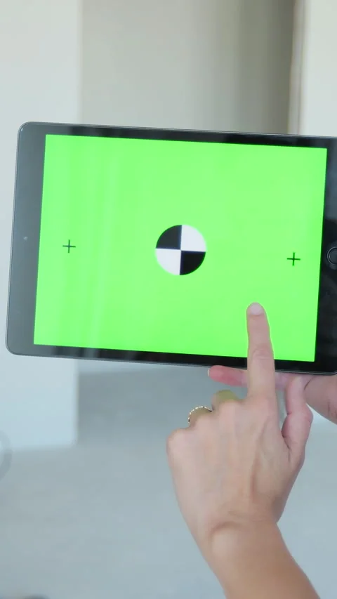 Vertical video Woman uses a tabletPC with a green on the background Stock Footage 339061908