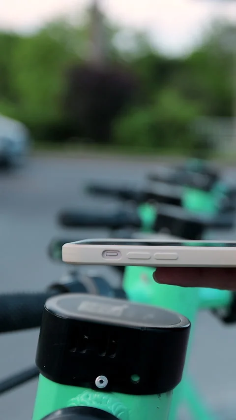 Vertical video. Woman using app on smartphone to unlock electric scooter Видео 344430257