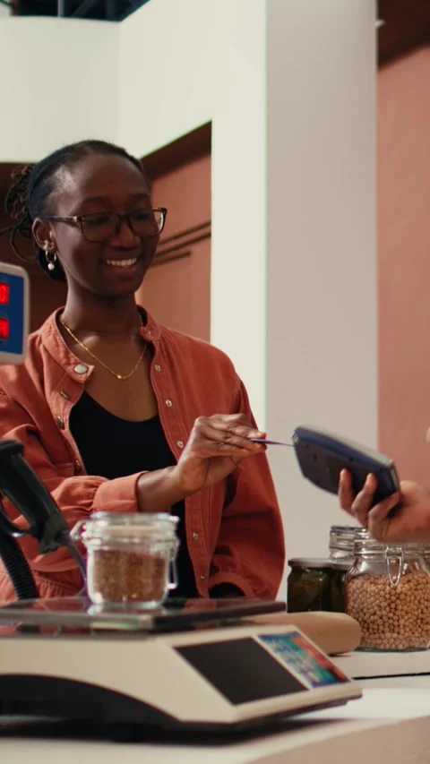 Vertical Video Woman using card payment at pos to buy fresh produce Stock Footage 262052280
