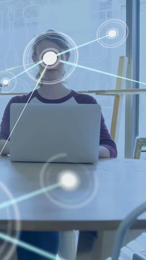 Vertical video: Woman using laptop, camera revealing and sparking nodes over her Stock Footage 334598601