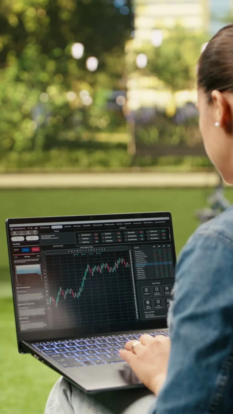 Vertical Video Woman using laptop with financial trading platform and Stock Footage 344381262