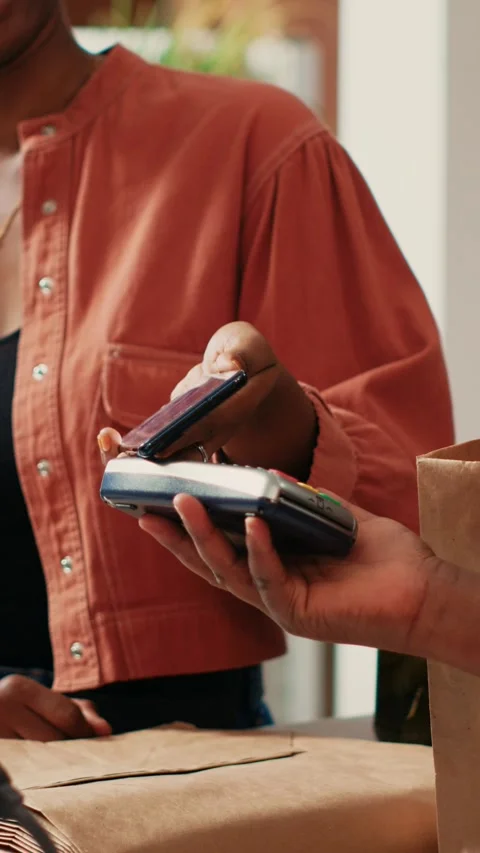 Vertical Video Woman using mobile nfc payment to pay for bio produce Stock Footage 262052211