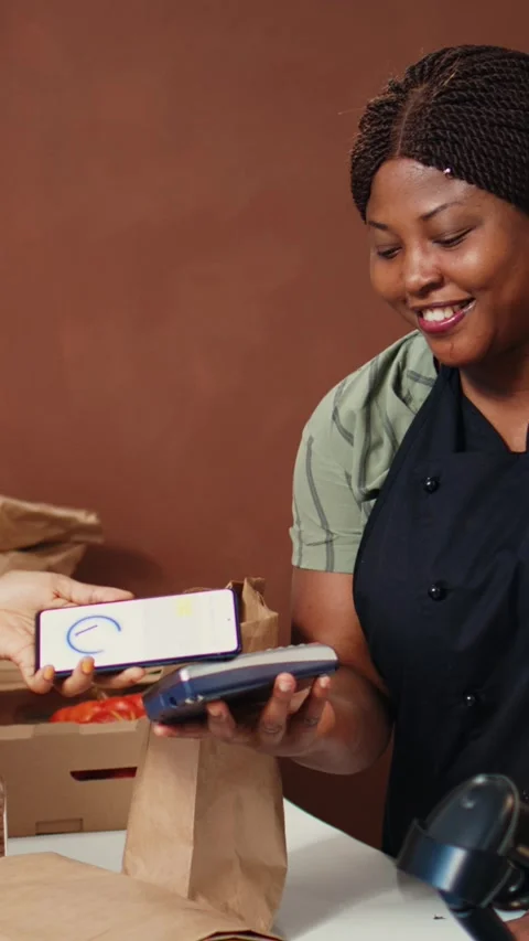 Vertical Video Woman using nfc mobile payment to purchase organic food Stock Footage 262051175