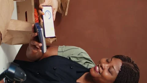 Vertical Video Woman using nfc mobile payment to purchase organic food Stock Footage 262283126