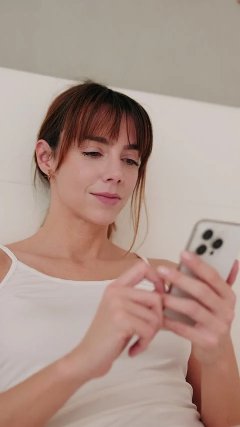 Vertical video, Woman Using Smartphone in Bed Stock Footage 304826498