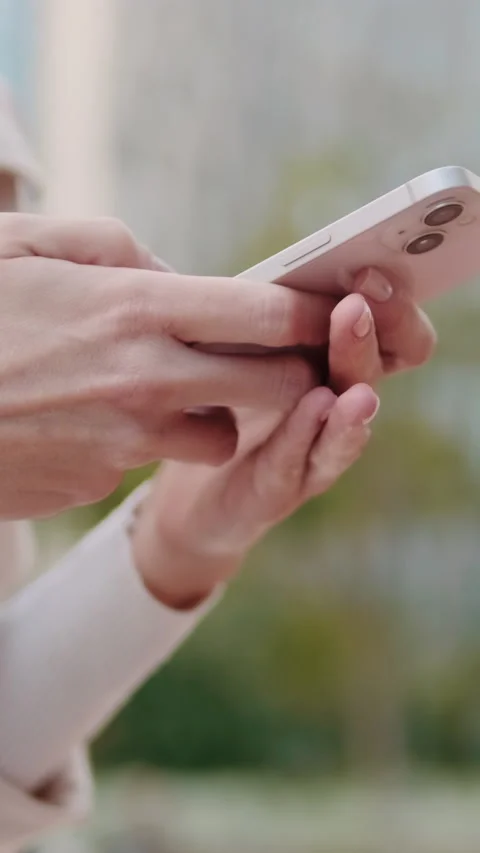 Vertical video, Woman Using Smartphone in the City. Focus on the phone in female Stock Footage 312639403