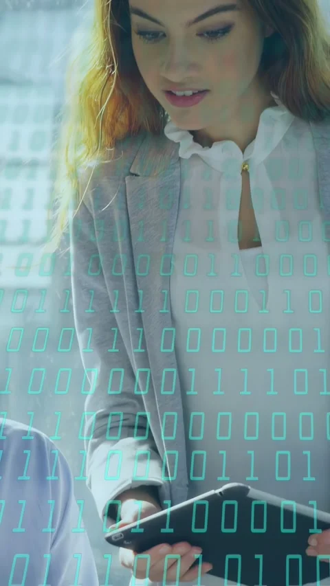 Vertical video: Woman using tablet, showing data to peer while binary digits Stock Footage 335802585