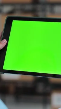 Vertical video. Woman using tablet computer with green screen chromakey displ Stock Photos