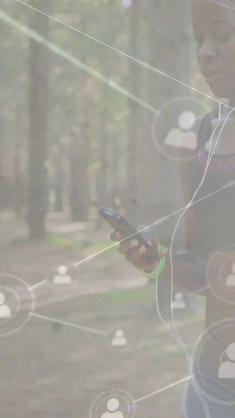 Vertical video: Woman walking path, tapping phone making icons grow over her and Video stock 332594498