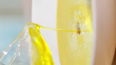 Vertical video. A woman's hand pours olive oil into the soup from a glass cup. Video stock 250454489