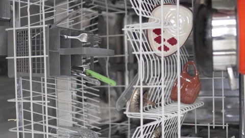 Vertical video. A woman's hand takes clean dishes out of the dishwasher Stock Footage 239613140