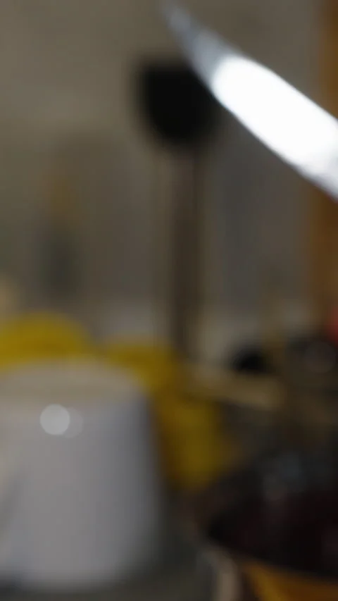Vertical video. A Woman's Hands In The Kitchen Cut Cherries In Half And Remove Stock Footage 277570541
