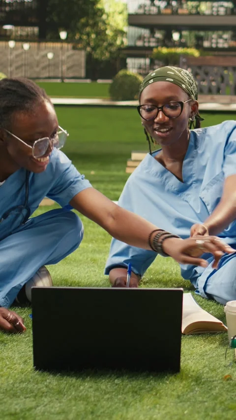 Vertical Video Women students team in blue scrubs work together with laptop and Stock Footage 341321353