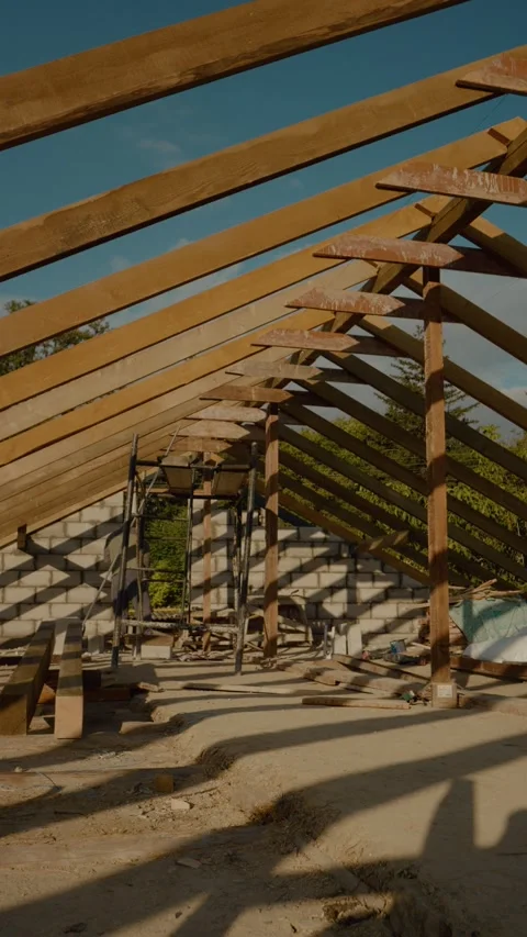 Vertical video Worker constructs wooden roof beams on porch in bright afternoon Stock Footage 327601513