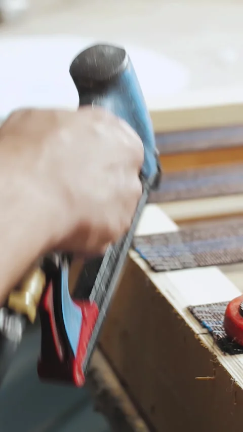 Vertical video. Worker making sofa in furniture factory using power tools. Close Stock Footage 323451293