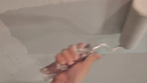 Vertical video, Worker roller paints a wall Stock Footage 130950931