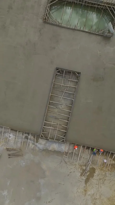 Vertical Video: Workers pour concrete into the foundation of a housing complex Stock Footage 297666903