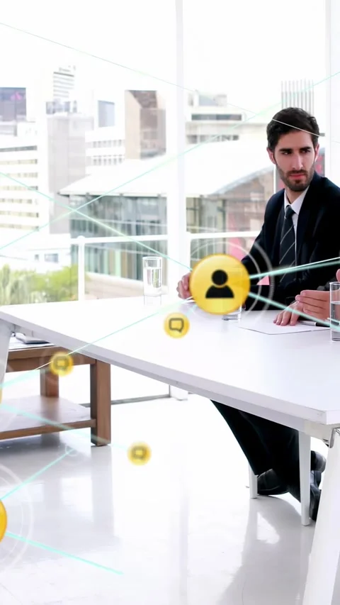 Vertical video: Yellow icon appearing above table, man using phone, nodes Stock Footage 334550351