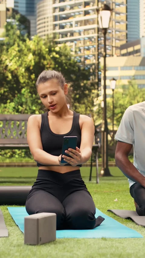 Vertical Video Yoga instructor guiding man through side stretch exercise Stock Footage 346615829