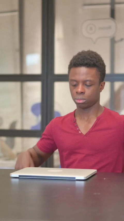 Vertical video of Young African Man Coming, Opening Laptop to Work Video stock 303218342