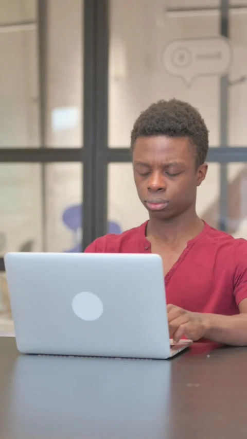 Vertical video of Young African Man Working on Laptop, Typing Email Video stock 303219906