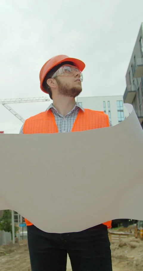 Vertical video. Young architect with hard hat holding blueprint Stock Footage 345504307