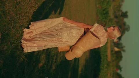 Vertical video of the young beautiful blond woman in the long summer dress with Stock Footage 257868435