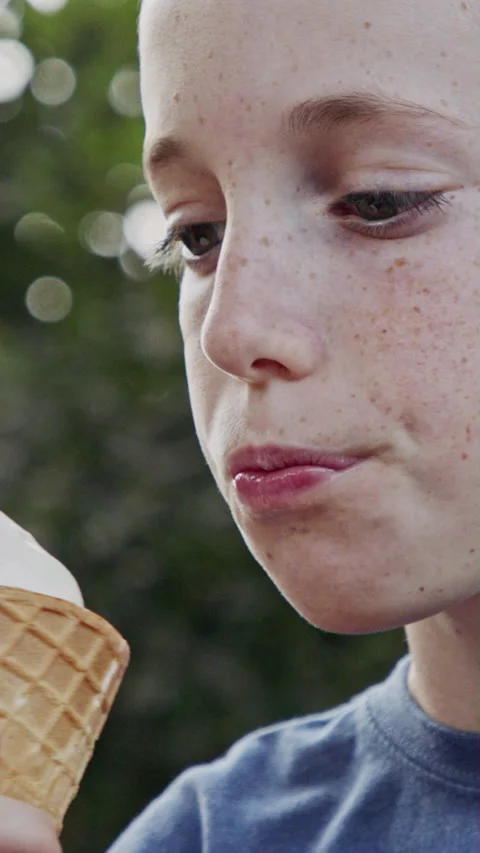 Vertical video of Young boy eating Ice Cream from a cone, enjoying and laughing Stock-Footage 206304867