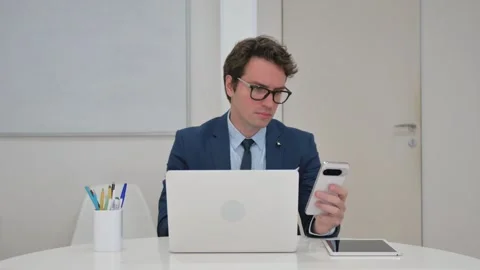 Vertical Video, Young Businessman Using Phone and Laptop Video stock 312914246