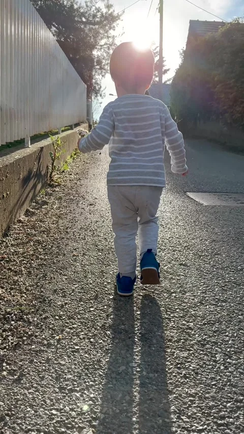 Vertical Video of Young Child Exploring Grass and Garden Plants 库存影片 345163575