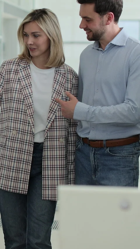 Vertical video Young couple discussing chosen auto in automobile showroom. Stock-Footage 337238556