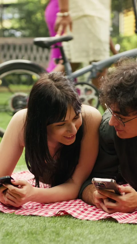Vertical Video Young couple laughing together and reacting to funny videos on Stock Footage 341472580