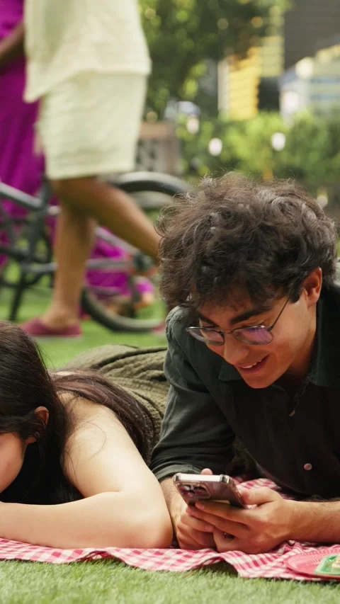 Vertical Video Young couple laying side by side illustrating phubbing and phone Stock Footage 341472544