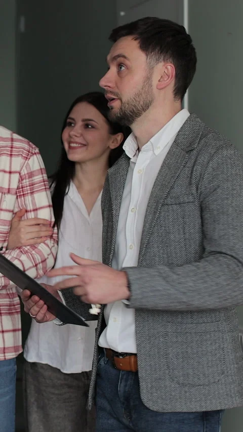 Vertical video Young couple with real-estate agent visiting apartment Stock Footage 340081734