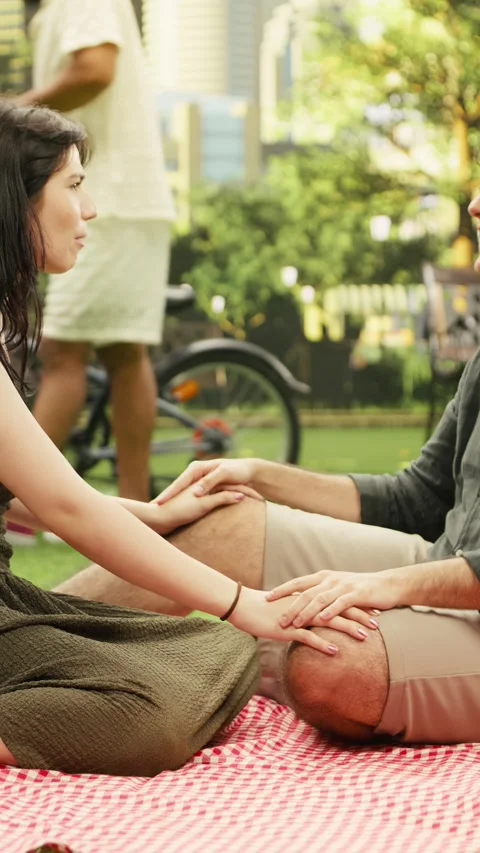Vertical Video Young couple sitting and talking on romantic picnic date together Stock Footage 341472382
