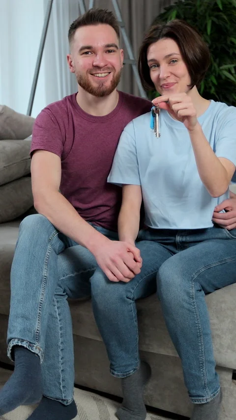 Vertical video. Young couple on sofa near cardboard boxes Stock Footage 346201440