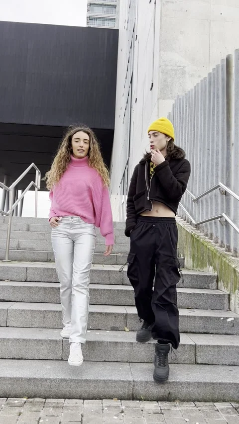 Vertical video of a young couple walking down stairs while having a conversation Stock Footage 259853320