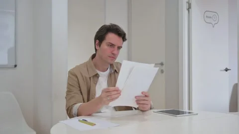 Vertical Video, Young Creative Man Reading Documents at Work Stock Footage 312914115