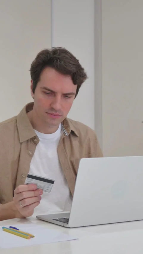 Vertical Video, Young Creative Man Enjoying Online Banking on Laptop Stock Footage 318044973