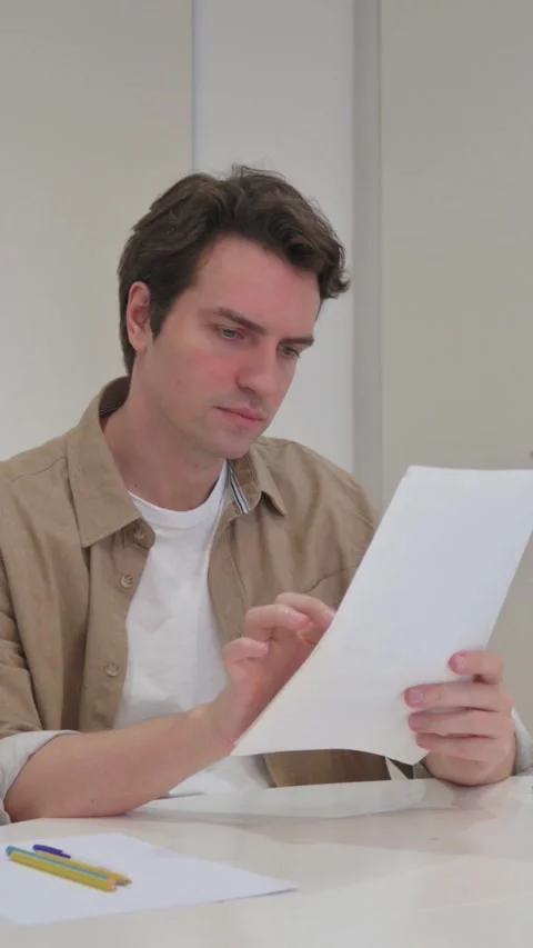 Vertical Video, Young Creative Man Reading Documents at Work Stock-Footage 318045696