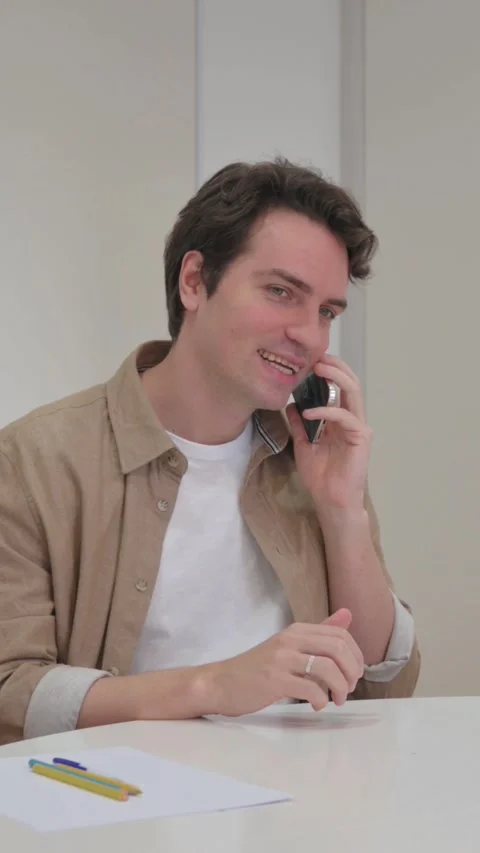 Vertical Video, Young Creative Man Talking on phone with Client Video stock 318045735