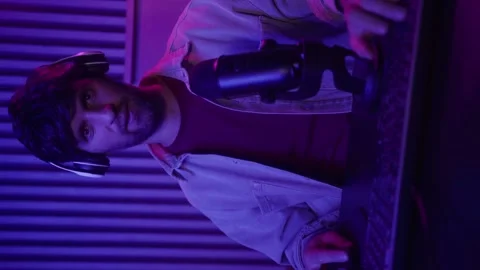 Vertical video: A young man is actively engaging with his audience during a live Vídeo Stock 282356061