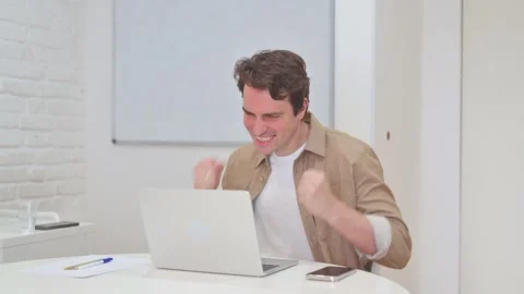 Vertical Video, Young Man Celebrating Success while Working on Laptop Stock Footage 312914333