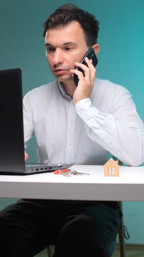Vertical video young man communicating by mobile phone and using laptop for Stock Footage 342771291