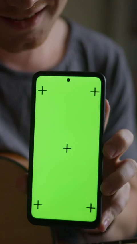 Vertical video: Young man plays guitar learns from smartphone app. Smartphone Stock Footage 298729708