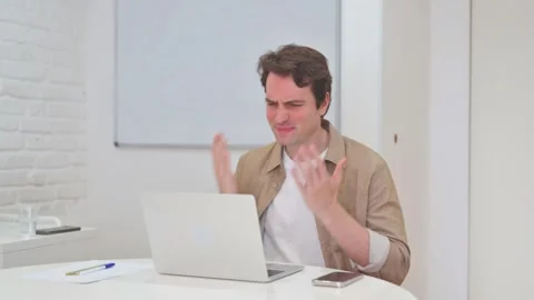 Vertical Video, Young Man Reacting to Loss while Working on Laptop Stock Footage 312914344