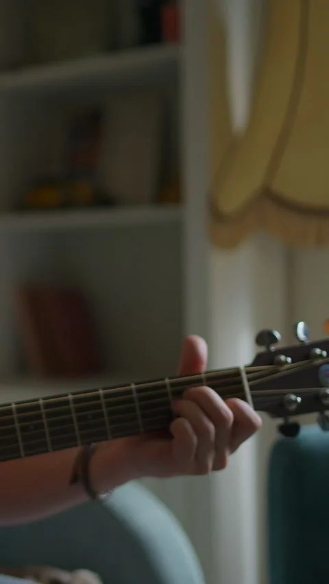 Vertical video: Young man is sitting with a guitar, a concert for advertising Stock Footage 303550942